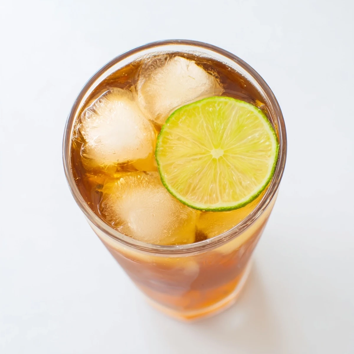Refreshing Thai lime iced tea served over ice with green lime wheel on rim