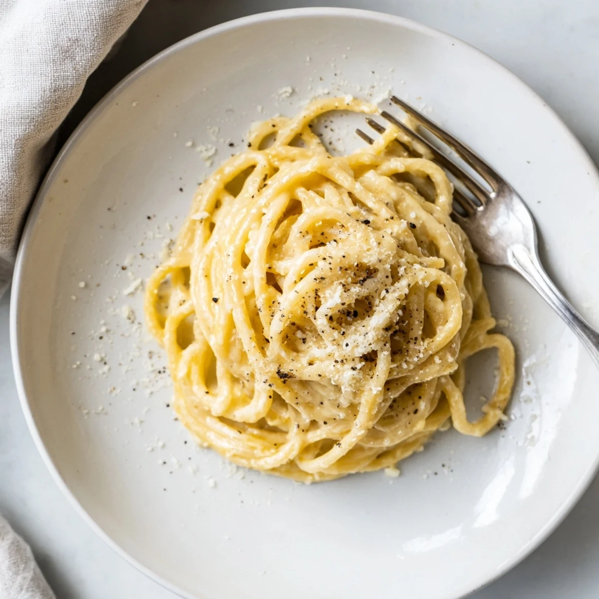 Creamy Cacio e Pepe pasta coated in melted Pecorino Romano and freshly ground black pepper