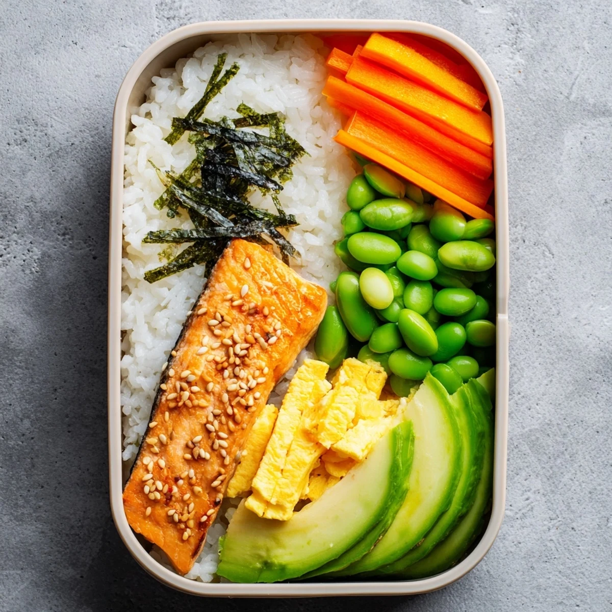 Nourishing Japanese breakfast bento featuring tender fish fillet alongside fluffy rice, tangy pickles, edamame, and vibrant seasonal fruit