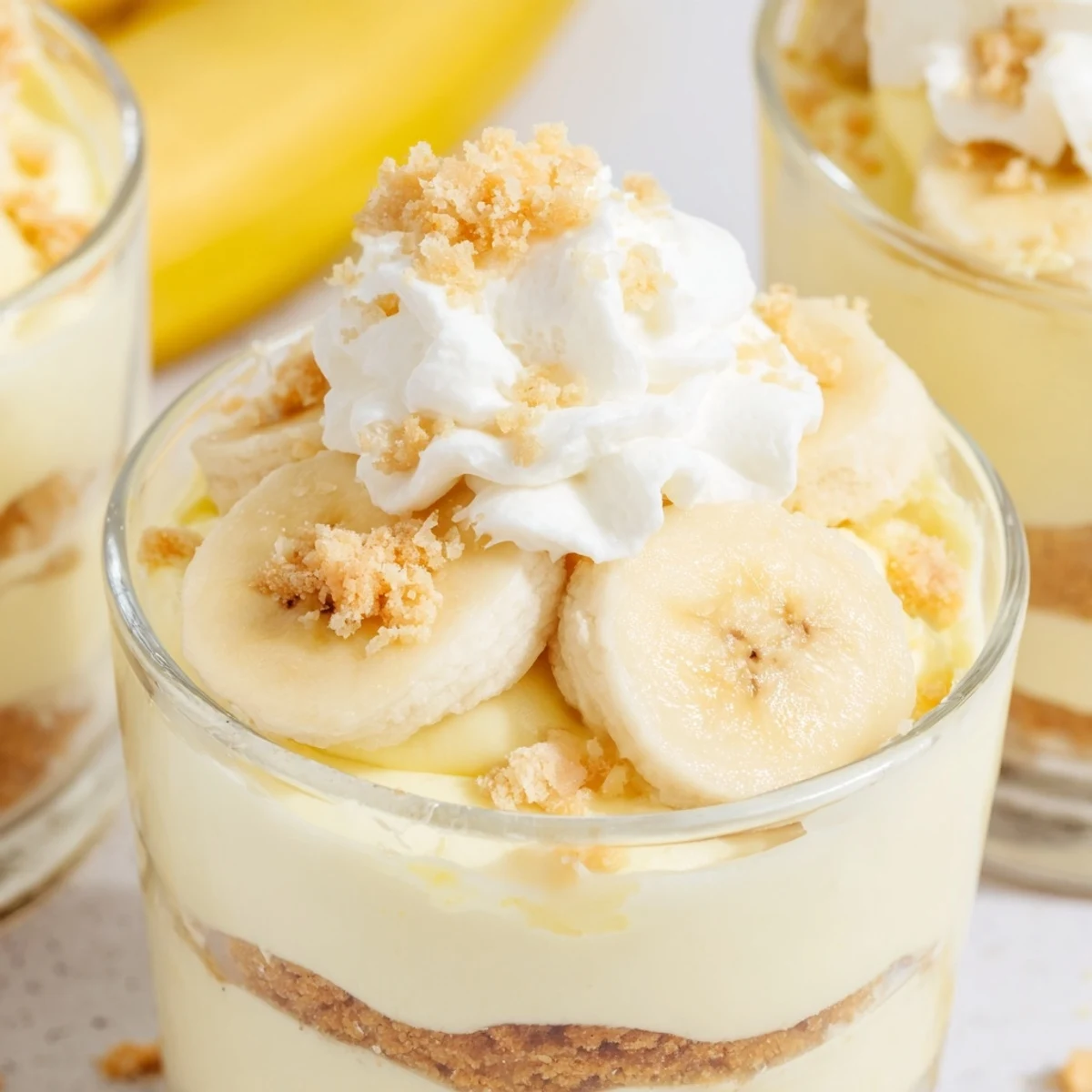 Creamy banana pudding cheesecake cups with layered vanilla wafer crust and fresh banana slices