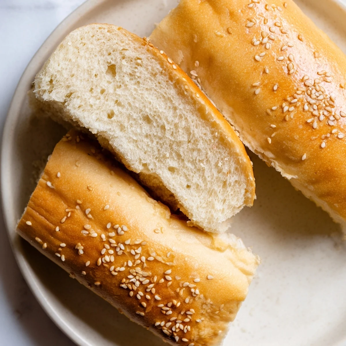 Soft homemade sourdough discard hot dog buns arranged on a wooden serving board