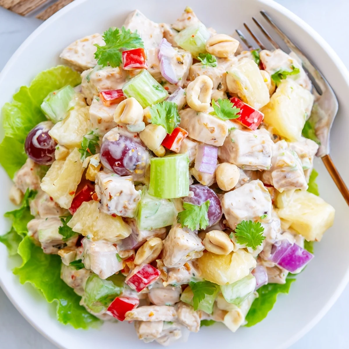 Hawaiian Chicken Salad Recipe served chilled on butter lettuce, bright cilantro garnish.