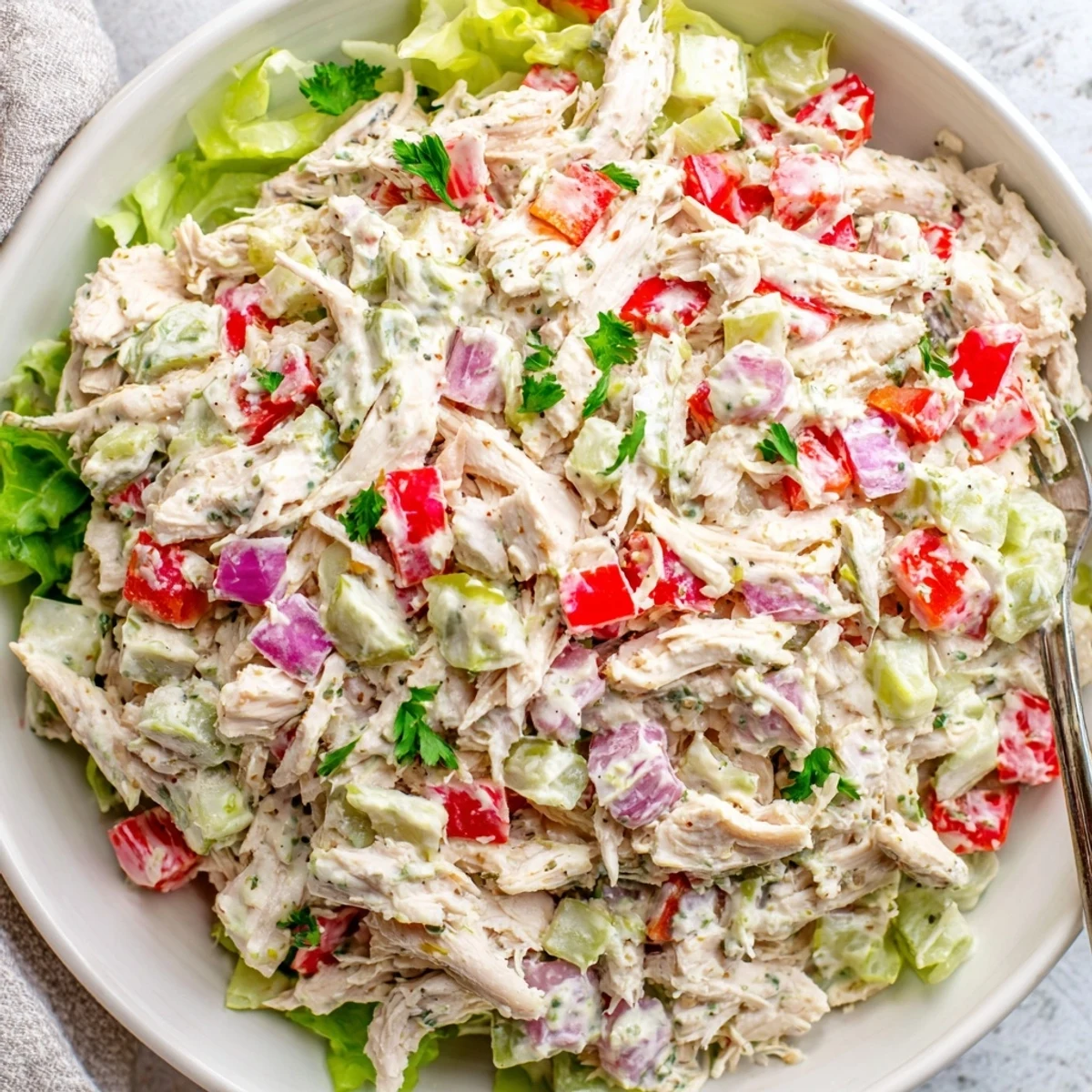 Tangy High Protein Pepperoncini Chicken Salad served over mixed greens, bright herbs