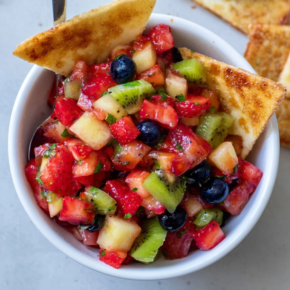 Homemade Fruit Salsa With Cinnamon Sugar Tortilla Chips plated for dipping, tangy, refreshing