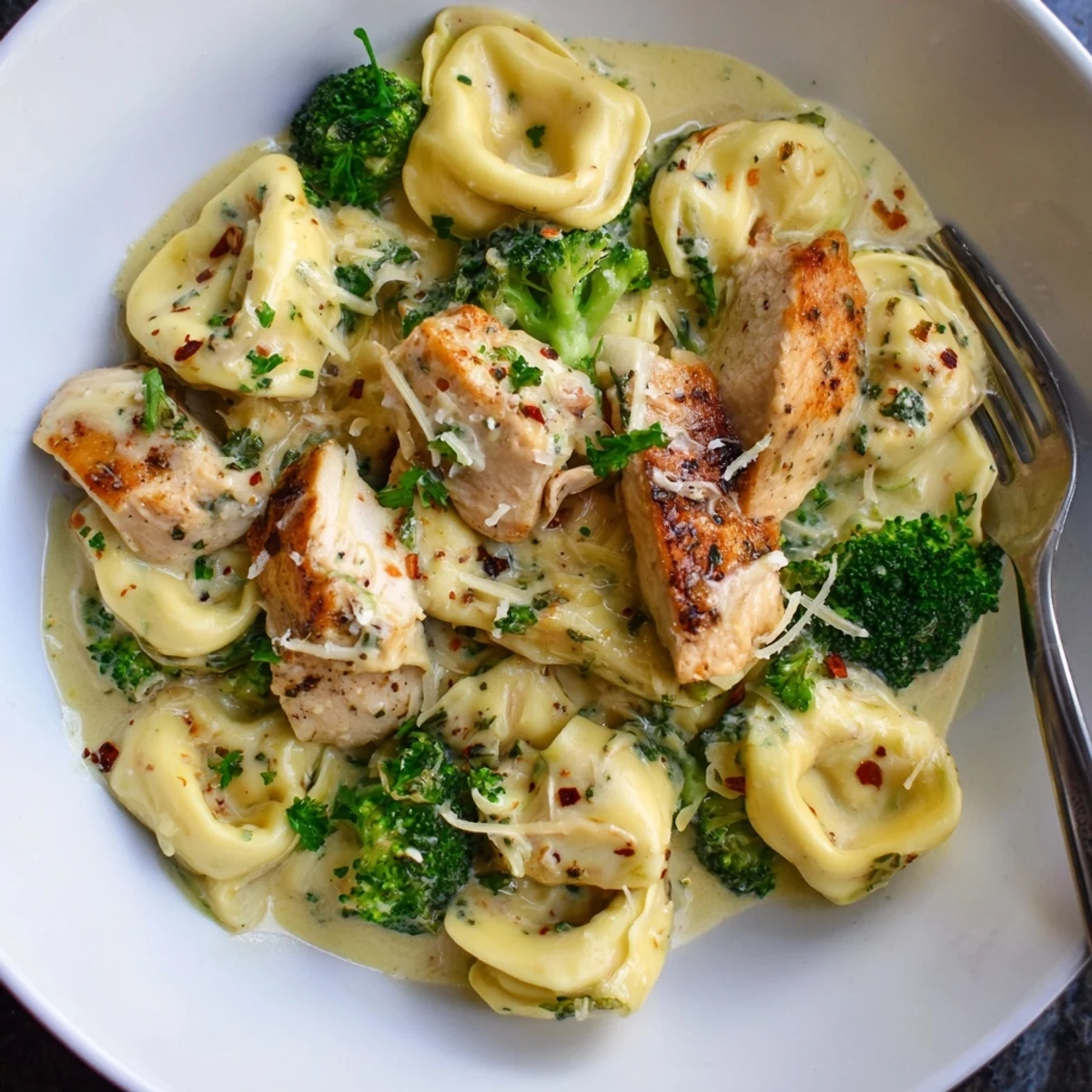 Creamy Garlic Parmesan Tortellini Chicken Broccoli Recipe plated steaming, fragrant garlic sauce, Parmesan sprinkle