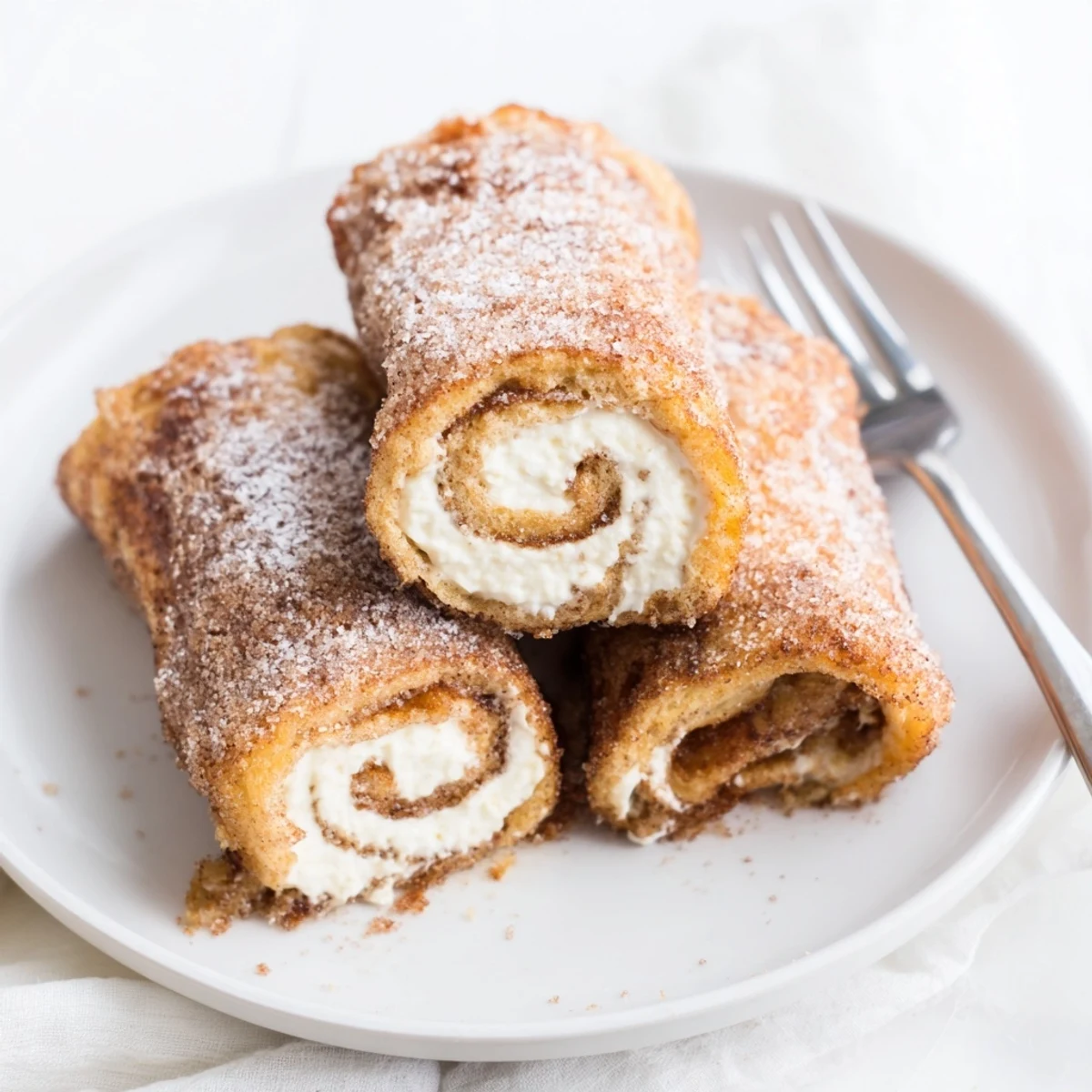 Cinnamon Roll French Toast Roll Ups steaming, golden, brushed with cinnamon sugar