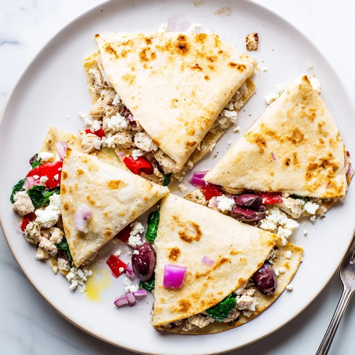 Sliced quesadilla wedges revealing juicy marinated chicken melted cheese blend and colorful diced veggies