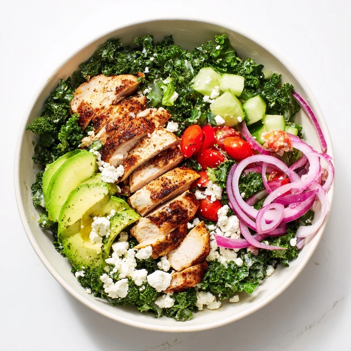 Sliced grilled chicken over massaged kale with cherry tomatoes and creamy yogurt dressing