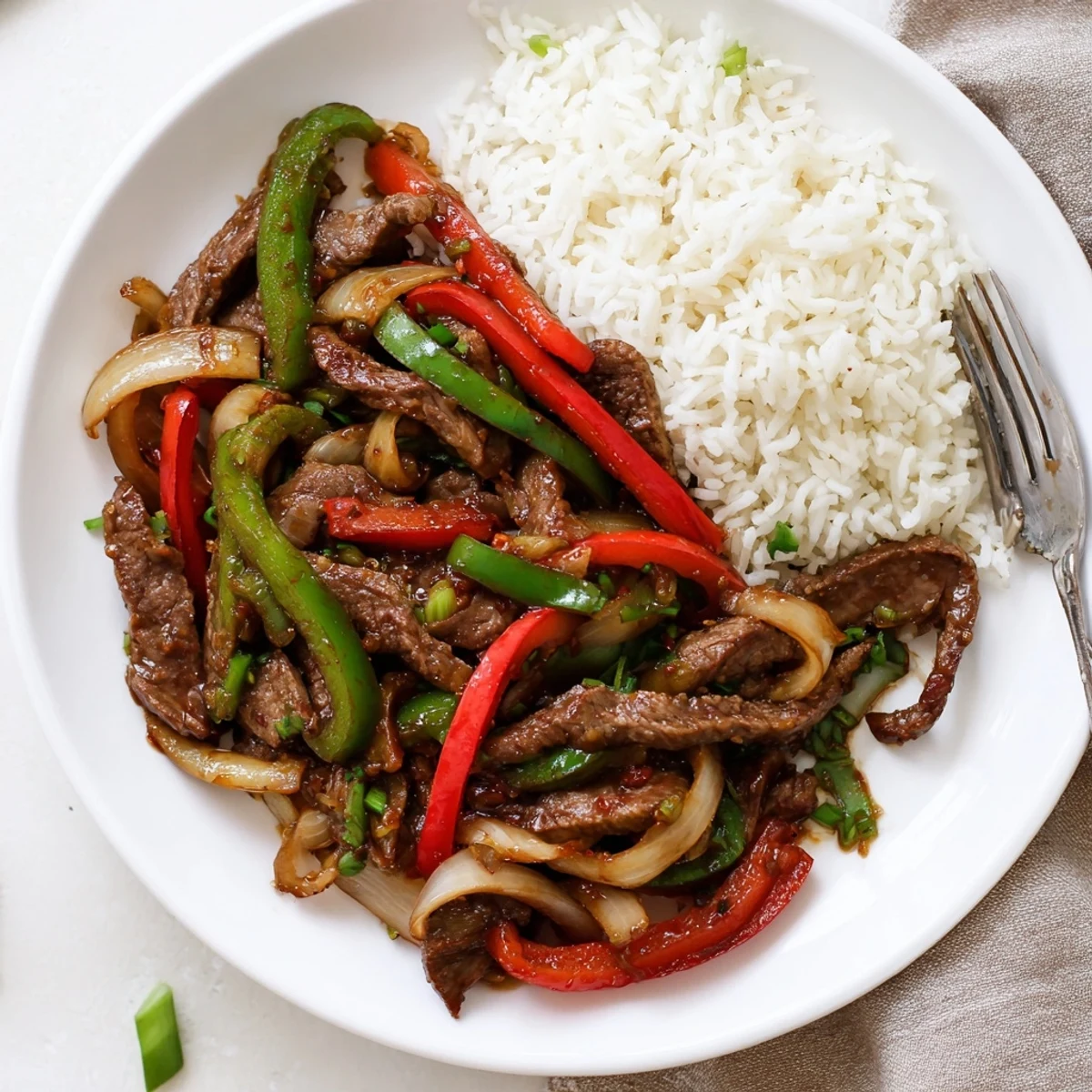 Sizzling spicy beef stir fry with chili garlic sauce served over fluffy white jasmine rice