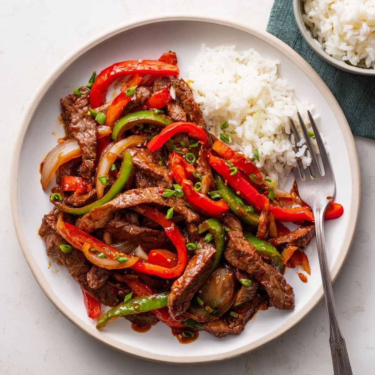 Tender strips of beef and colorful bell peppers tossed in bold spicy chili garlic stir fry sauce