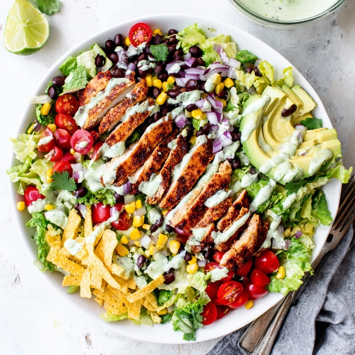 Colorful Southwestern chicken salad bowl with grilled chicken slices, avocado, black beans, corn, and creamy dressing