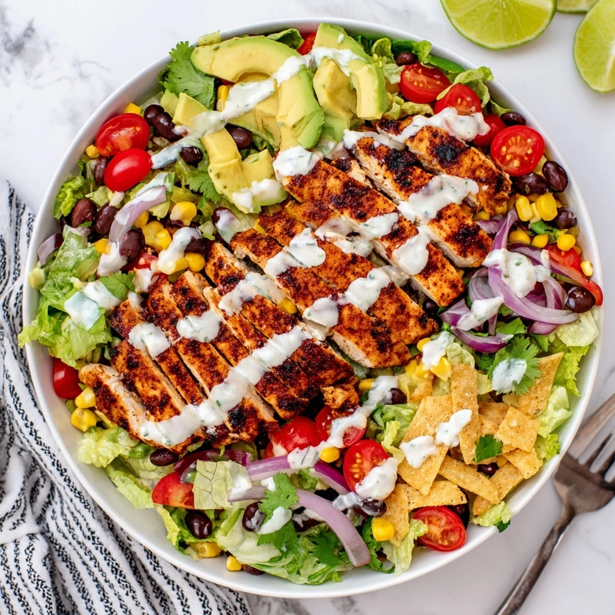Juicy spiced grilled chicken atop crisp romaine lettuce with vibrant veggies, cheese, and tortilla strips in Southwestern chicken salad