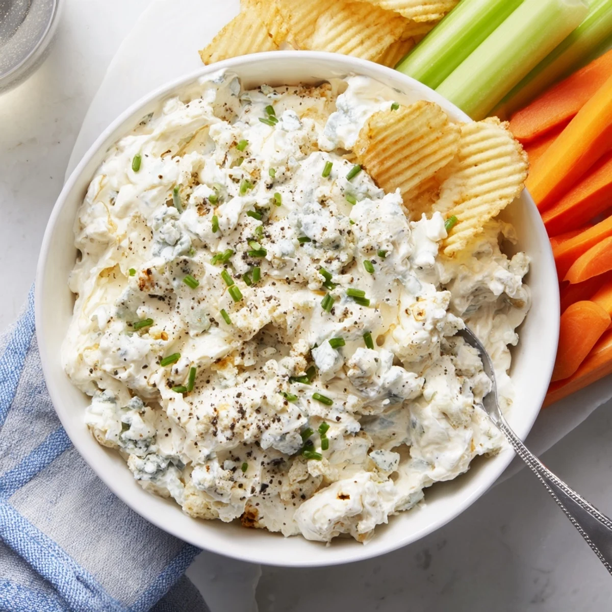 Velvety blue cheese dip served alongside buffalo wings and crisp vegetable crudité on a platter