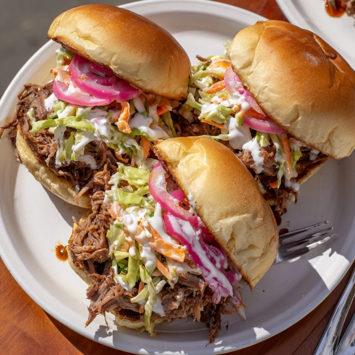 Juicy Alabama white sauce pulled lamb sliders piled high with crunchy creamy slaw on soft golden buns