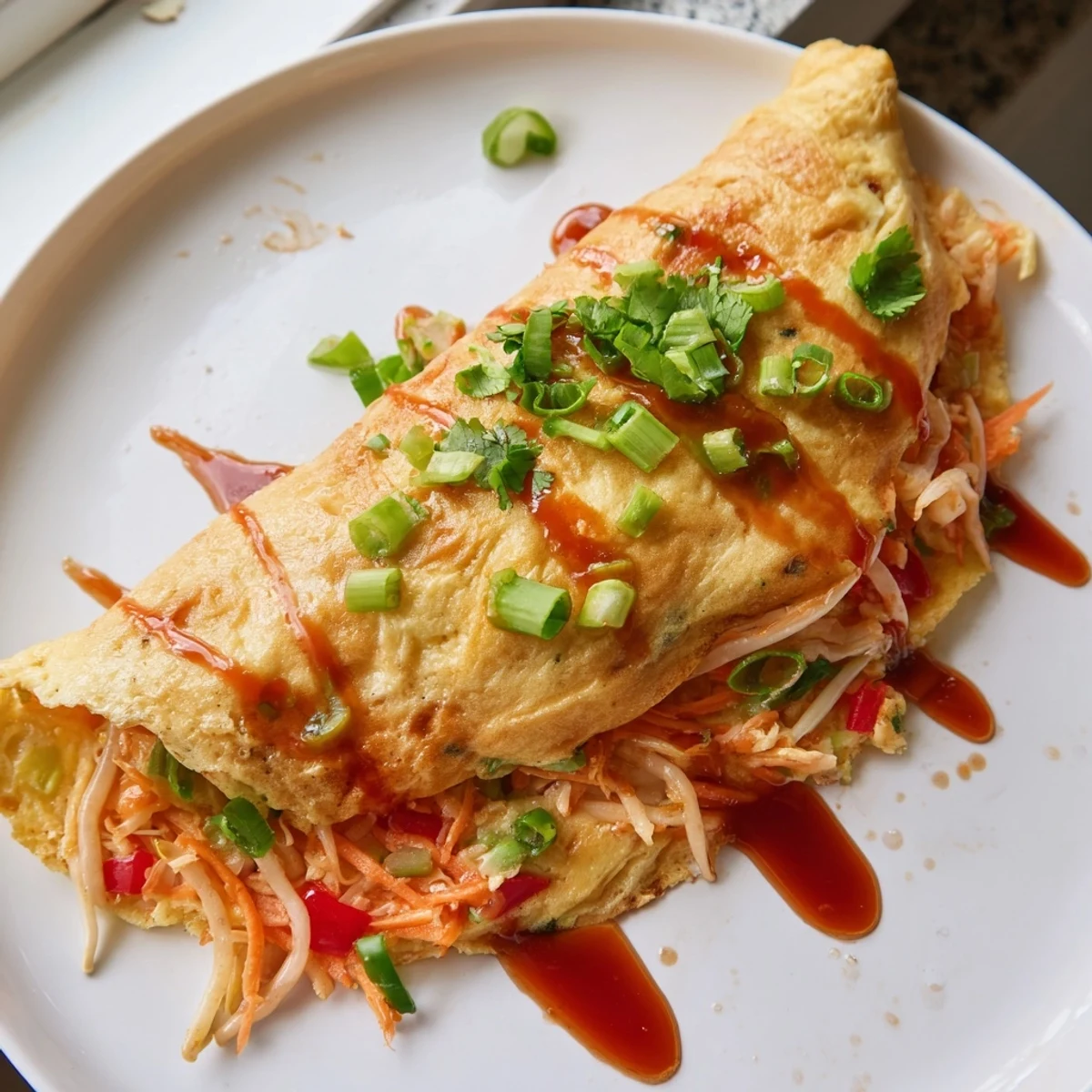 Fluffy Chinese omelette folded over tender bean sprouts and shredded carrots drizzled with sesame oil
