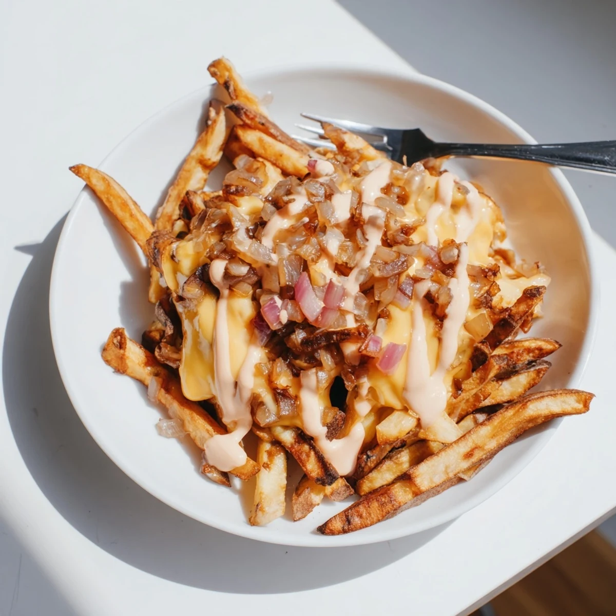 Steaming pile of In-N-Out Animal Style fries draped in gooey cheese and caramelized onions